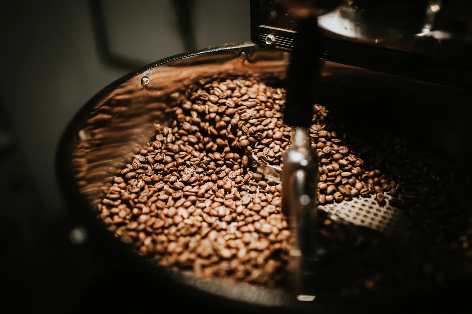 Grãos de café sendo torrados em equipamento artesanal